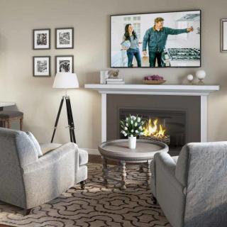 A cozy living room with a fireplace and television, featuring modern furniture and design elements.