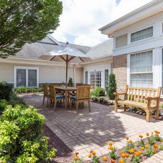 A cozy patio area with wooden furniture and a garden setting.
