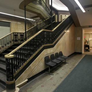 A spacious interior featuring a grand staircase and seating area.