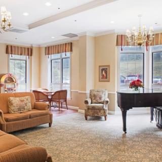 A cozy lounge with a grand piano and comfortable seating.