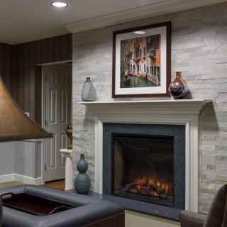 A cozy living room featuring a modern fireplace, decorated with artwork and vases.