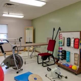 A physical therapy room filled with various exercise and rehabilitation equipment.