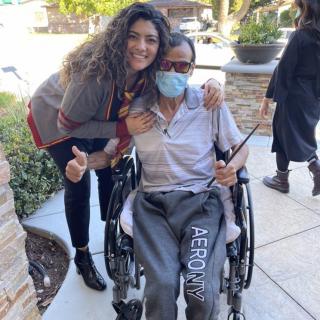 A cheerful moment outdoors with a person in a wheelchair and two companions.