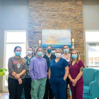 A dedicated team of healthcare professionals posing together in their workspace.