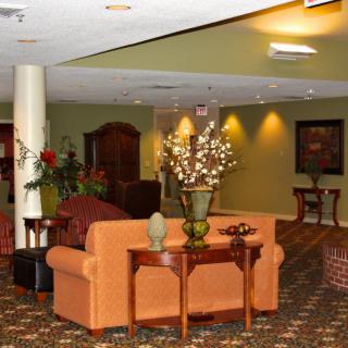A cozy lobby area with sofas and decorative plants.