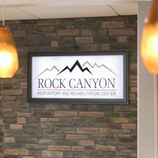 Interior view of a reception area showcasing the 'Rock Canyon' business sign on a brick wall.