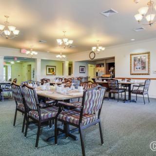 A well-lit dining area with neatly arranged tables and chairs.