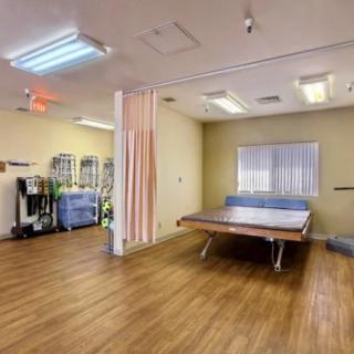A physical therapy room equipped with tables and exercise equipment.