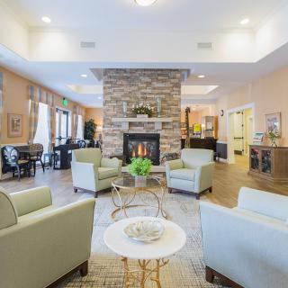 A modern living room with a central stone fireplace and comfortable seating arrangement.