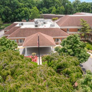 Aerial view of a modern residential home surrounded by lush greenery.