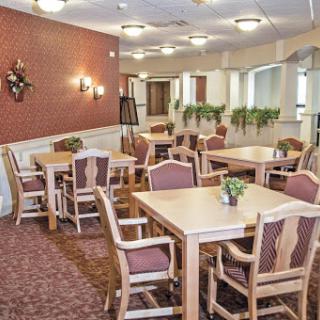 A cozy dining area with wooden tables and upholstered chairs, designed for community gatherings.