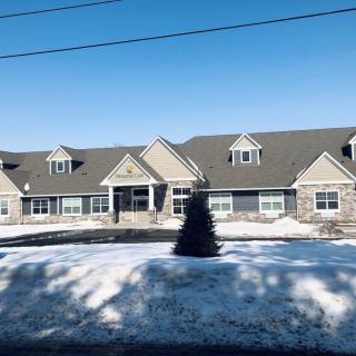 A suburban building surrounded by snow under a clear blue sky.