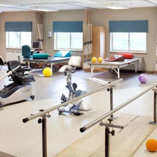 A rehabilitation room equipped with exercise machines and therapy tools.