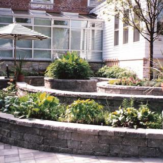 A terraced garden with stone retaining walls and lush greenery.