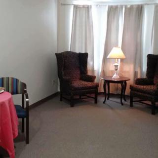 A cozy living room corner with two armchairs and a lamp on a side table.