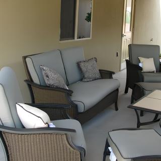 A cozy outdoor patio setup with comfortable seating and cushions.