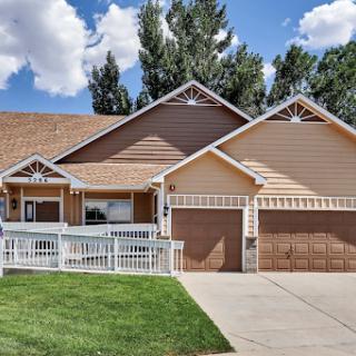 A charming suburban house with a garage and a well-maintained front yard.