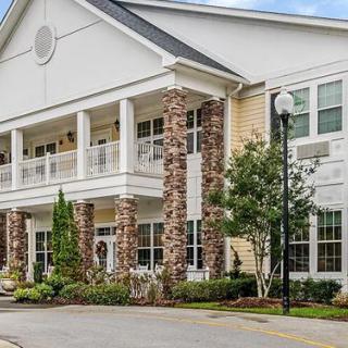 A two-story residential building with a porch and decorative columns.