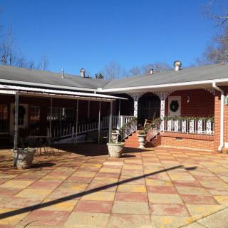 A sunny courtyard with a brick building and a spacious patio area.