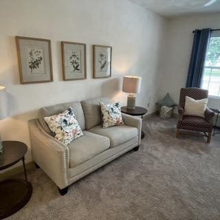 A cozy living room with a beige sofa, armchair, and tasteful decor.
