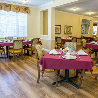 A neatly arranged dining room with tables set for guests.