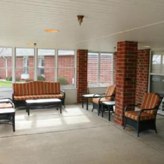 A cozy porch with comfortable seating and brick accents.