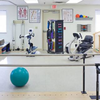A physical therapy room equipped with various exercise machines and tools.