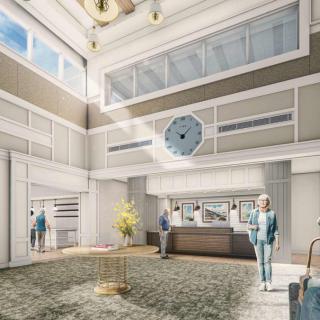 A modern and spacious lobby with a reception desk and large windows.