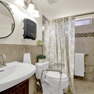 A clean and modern bathroom with a shower curtain and mirror above the sink.