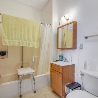 A clean and organized bathroom with a bathtub, shower, and yellow towel hanging.