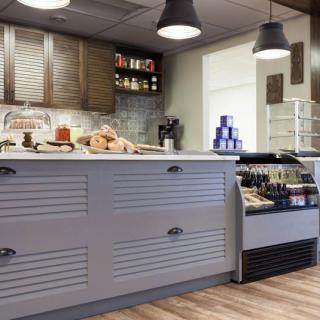 A modern cafe interior with a stylish counter and shelves stocked with various products.