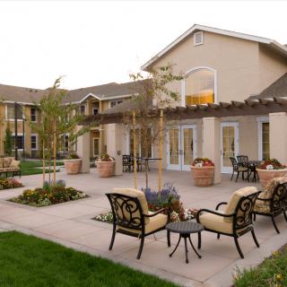 A well-maintained patio area with outdoor seating and a view of the adjacent building.