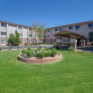 A residential building with a well-maintained lawn and garden in front.