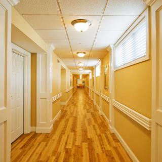 A long hallway with wooden flooring and soft lighting.