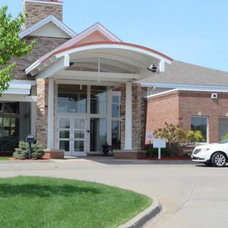 A building entrance with a driveway and a parked car.
