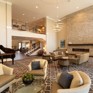 A spacious and modern living room with luxurious furnishings and a grand piano.
