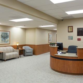 A clean and modern office reception area with seating and a desk.