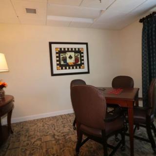 A small meeting room with a table, chairs, and artwork on the wall.