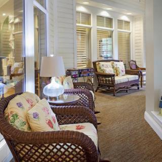 A cozy living room with wicker furniture and decorative pillows.