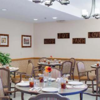 A cozy dining area with neatly set tables and wall decorations.