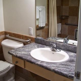A clean and modern bathroom with a marble countertop and mirror.