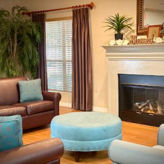 A cozy living room featuring comfortable seating, a relaxing atmosphere, and a warm fireplace.
