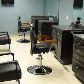 An empty barber shop with chairs and mirrors lined up against the wall.