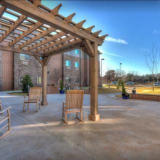 A serene outdoor seating area under a wooden pergola, perfect for relaxation.
