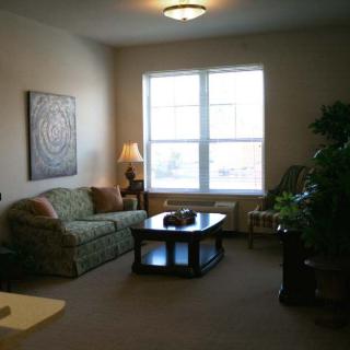 A cozy living room with a sofa, coffee table, and large window letting in natural light.