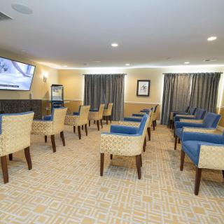 A well-lit meeting room with arranged chairs and a television.