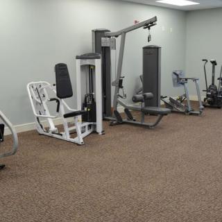 A gym with various exercise equipment and workout machines.