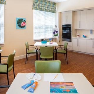 A bright, open dining and kitchen area with modern furnishings and colorful artwork.