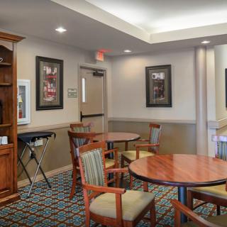 A cozy lounge area with round tables, chairs, and wall artwork.
