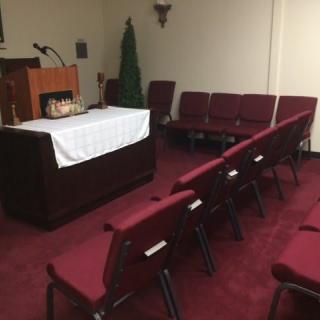 A small chapel with red seating and a podium at the front.